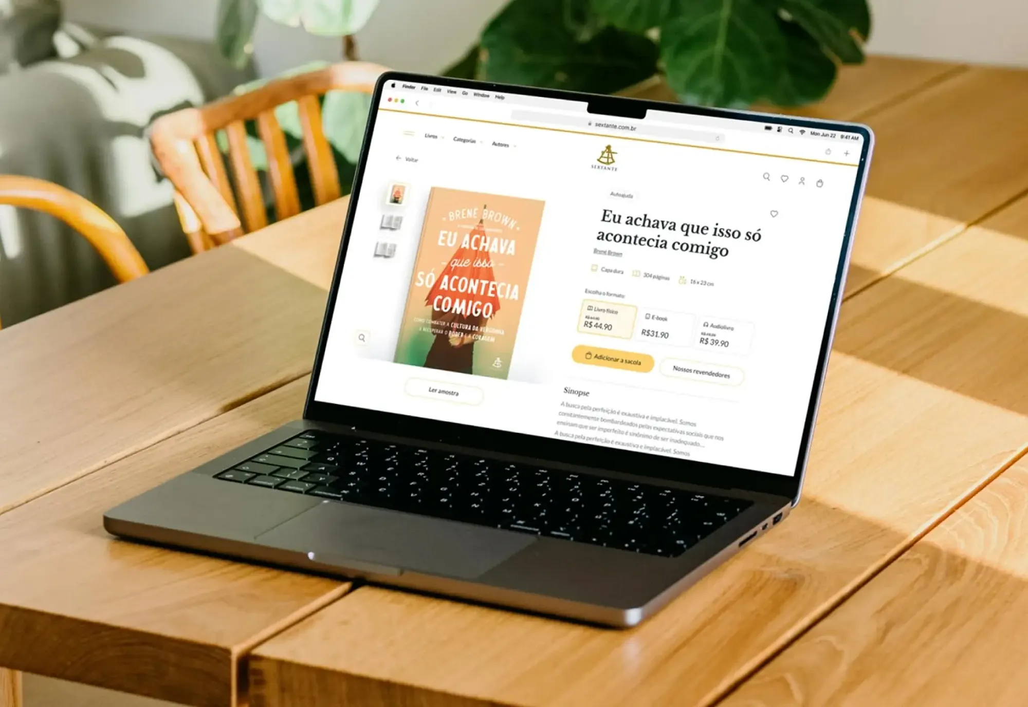 A laptop on a wooden table showing a product page of the Sextante online bookstore.